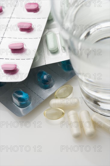 Many pills in packages with water.