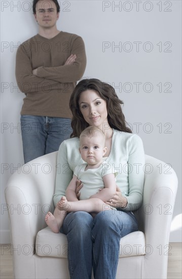 Woman seated with infant and man.