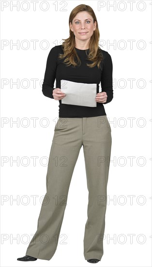 Woman standing holding papers.