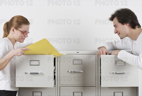 Couple gazing lovingly over file cabinets.