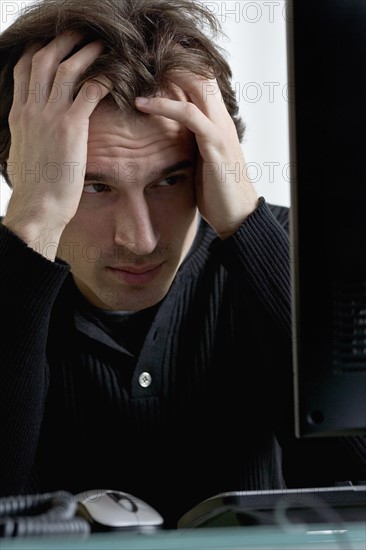 Closeup of distressed man with computer.