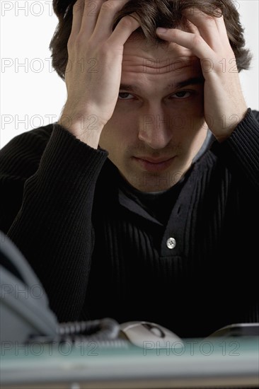 Closeup of upset man at desk.