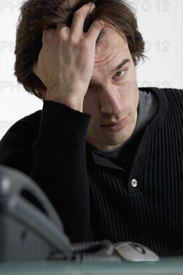 Closeup of exhausted man at desk.