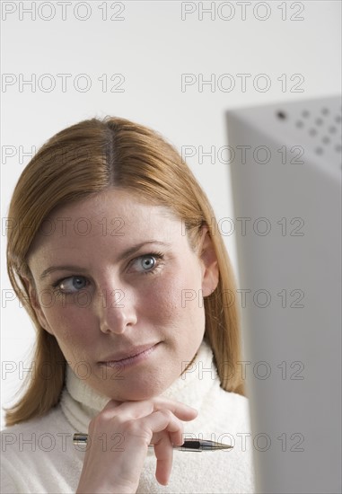 Thoughtful woman at computer.
