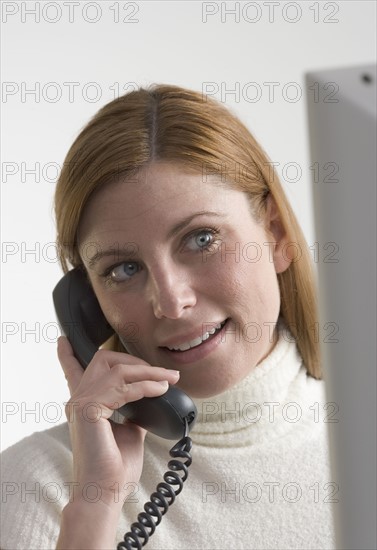 Woman on telephone with computer.