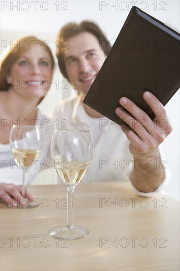 Couple with wine paying their bill.