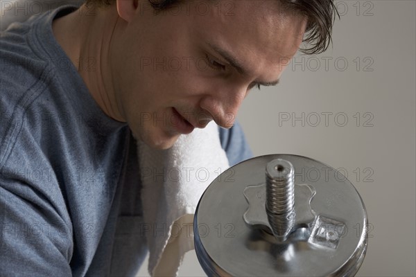 Closeup of man lifting weights.