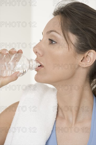 Woman drinking from water bottle.