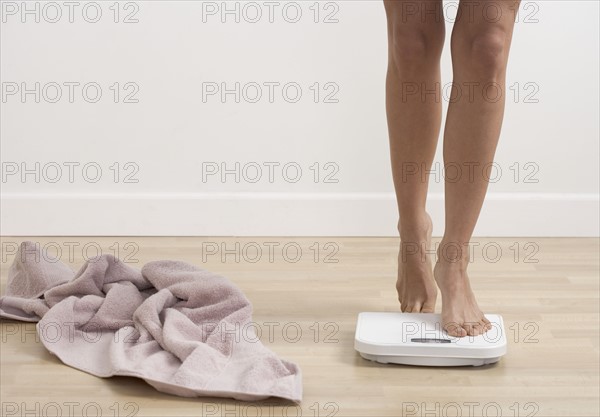 Feet stepping onto bathroom scale.