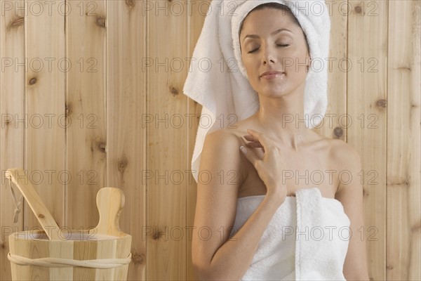 Woman relaxing in sauna.