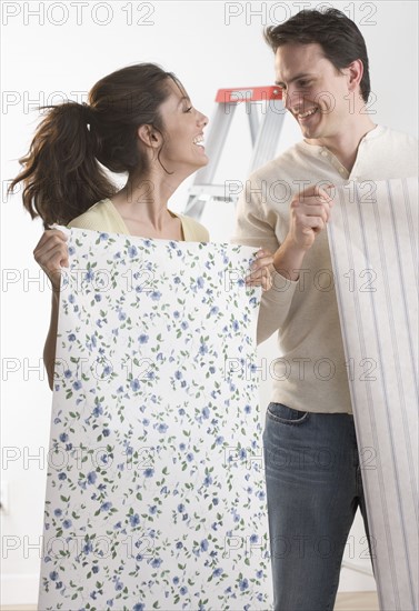 Couple with wallpaper and ladder.