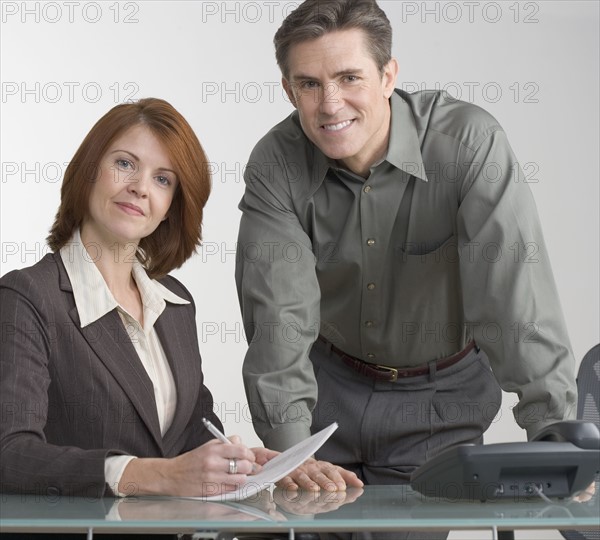 Business colleagues conferring at desk.