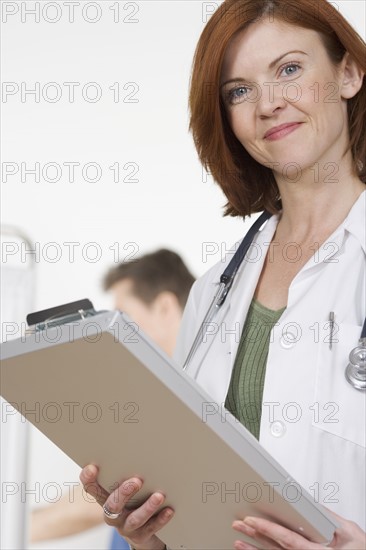 Smiling healthcare professional with chart.