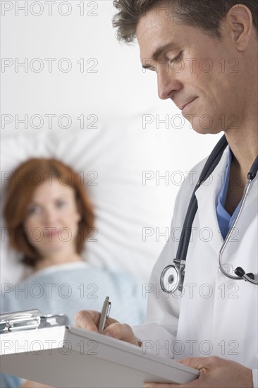 Doctor taking notes with patient.