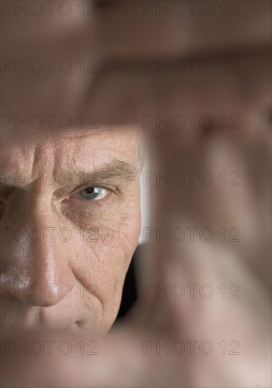 Hands framing face of a man.