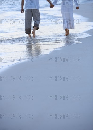 Couple walking along a beach.