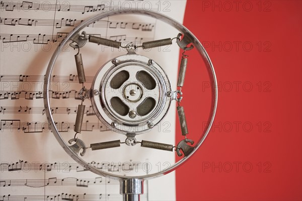 Still life of microphone and sheet music.