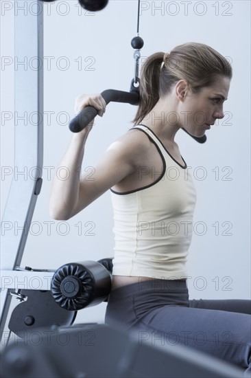 Woman working with resistance machine.