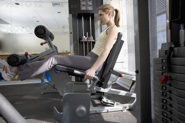 Woman working with resistance machine.