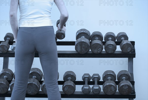 Woman selecting weights.