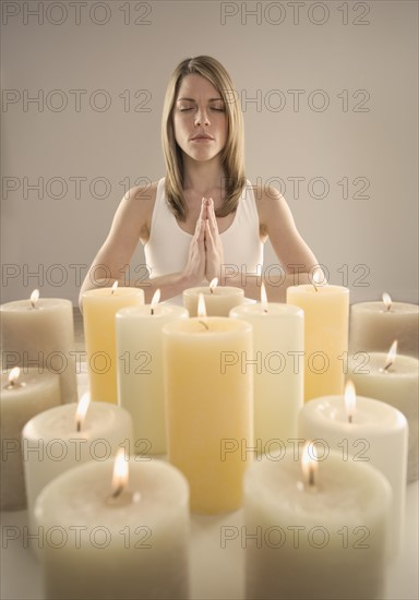 Woman meditating by candlelight.