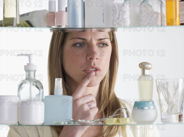 Woman looking into medicine cabinet.