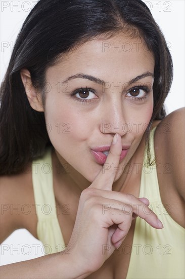 Portrait of woman with finger to lips.