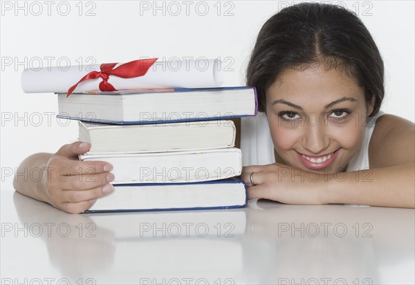 Woman with textbooks and diploma.