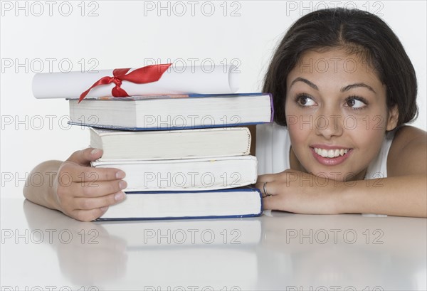 Woman with textbooks and diploma.