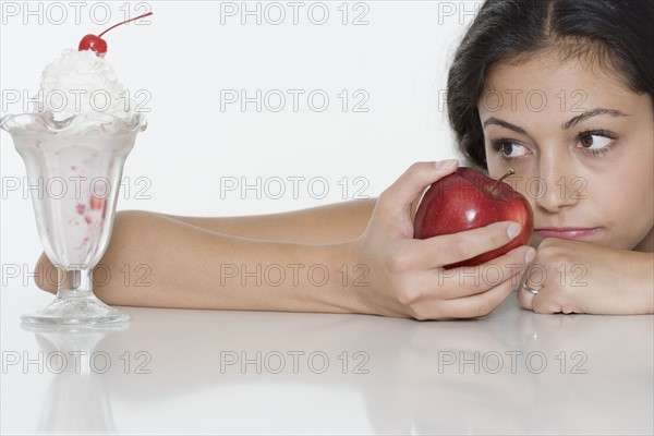 Woman with apple wanting ice cream sundae.