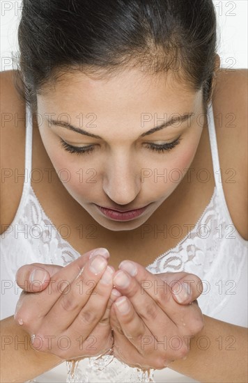 Woman with water cupped in hands.