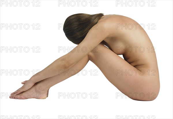 Profile of nude woman sitting.