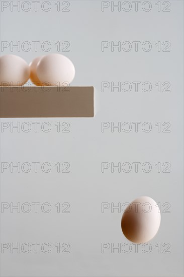 Egg falling off edge of table.