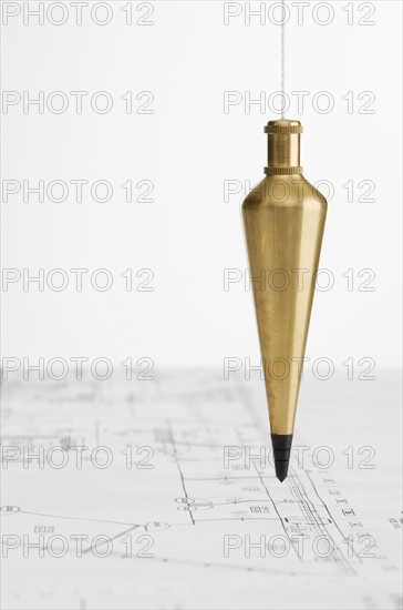 Plumb bob with blueprints.