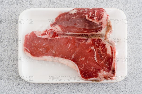 Raw steak on Styrofoam tray.