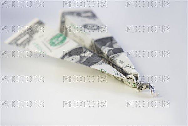 Still life of airplane made from dollar bill.