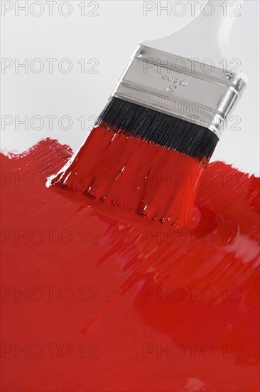 Still life of paint brush with red paint.