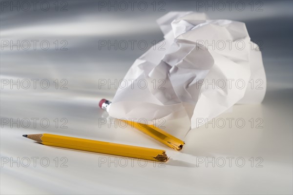 Closeup of broken pencil and crumpled paper.