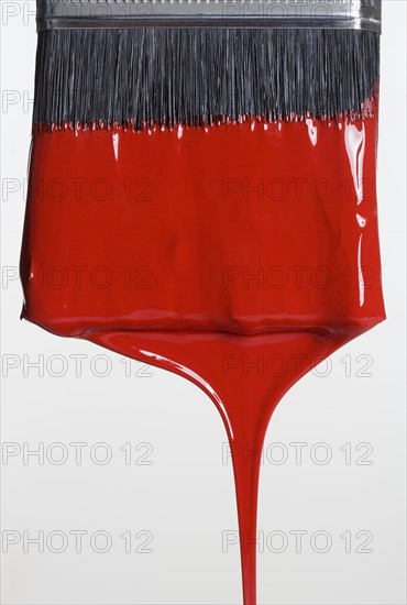 Still life of paint brush with red paint.