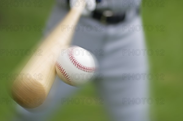 Closeup of baseball player hitting ball.