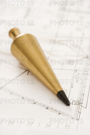 Plumb bob with blueprints.