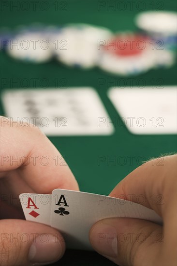 Hand holding two aces.