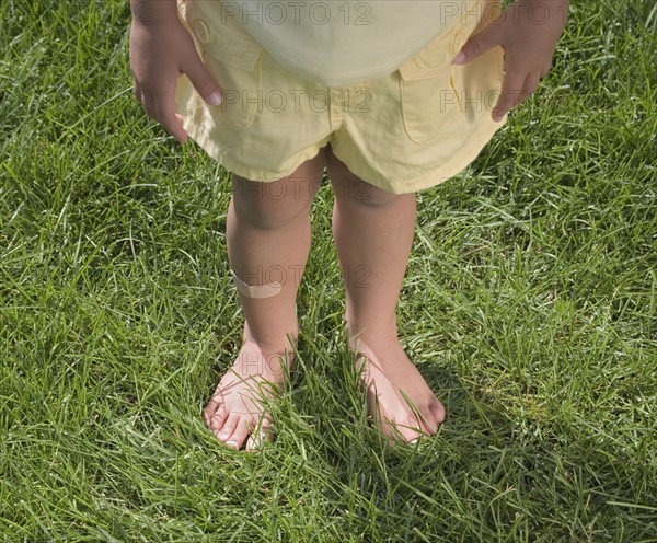 Child standing in bare feet.