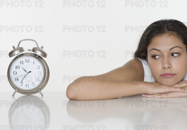 Woman looking at alarm clock.