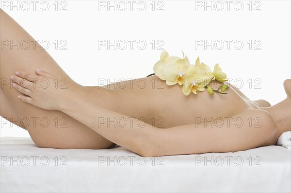 Closeup of nude woman with flowers.