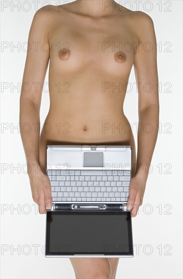 Nude female holding laptop computer.