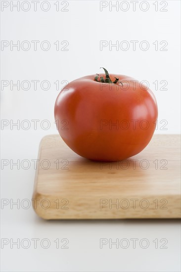 Fresh tomato on cutting board.