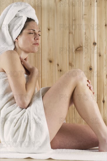 Woman relaxing in sauna.