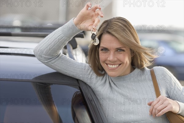 Woman holding keys to new car.