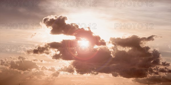 Sun peeking through dark cloud.